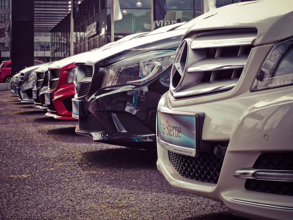 mercedes-benz-parked-in-a-row-164634 Luxury cars lined up at an outdoor dealership, showcasing sleek designs.